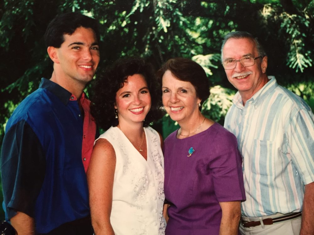 A young Diane smiling with her family outdoors