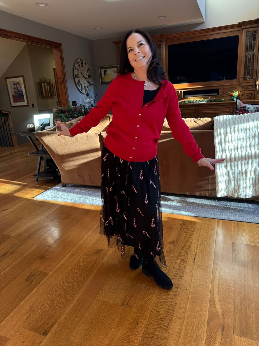 Diane twirling in her living room in a red cardigan