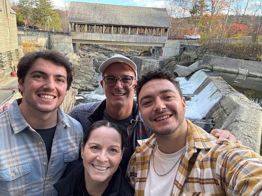 Diane with her family on a fall trip by a covered bridge