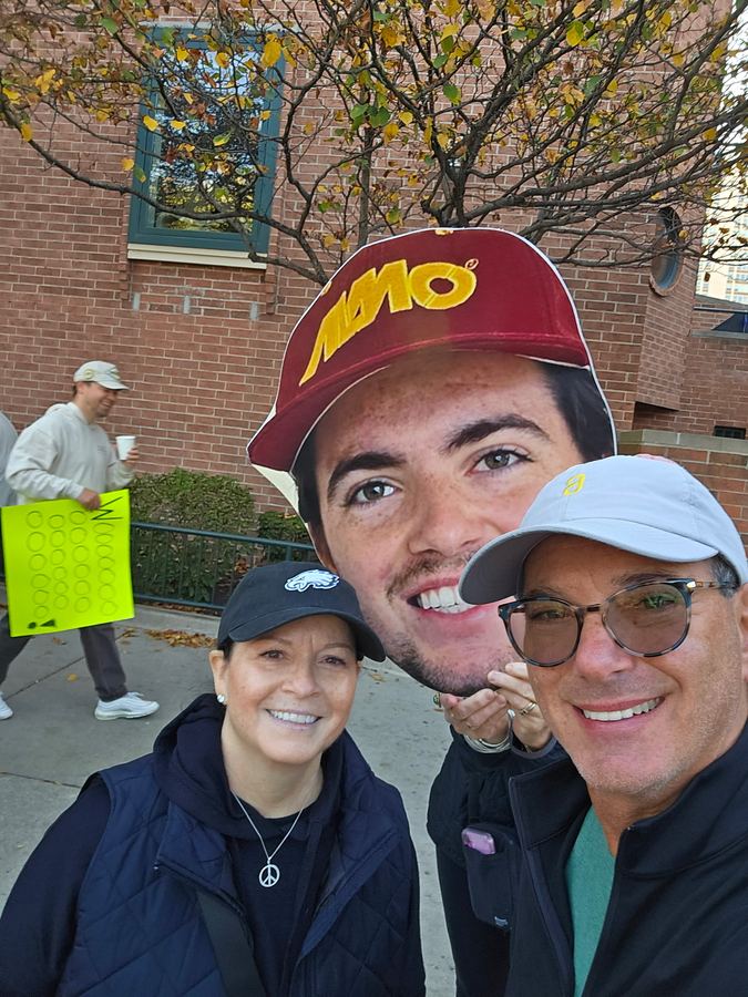 Diane and Warren cheering with a giant fan cutout