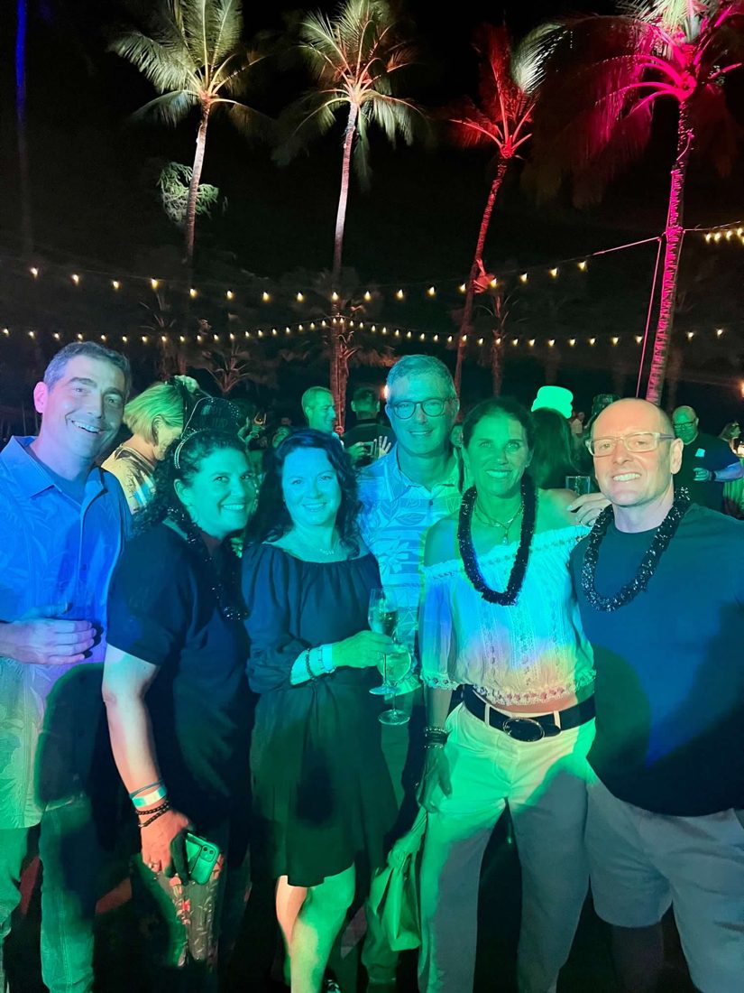 Diane with friends at a night party under lit-up palm trees