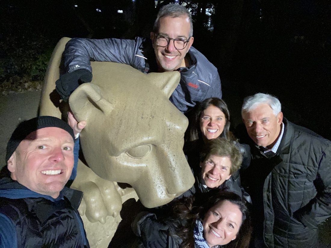 Diane and friends at night with the Nittany Lion statue at Penn State