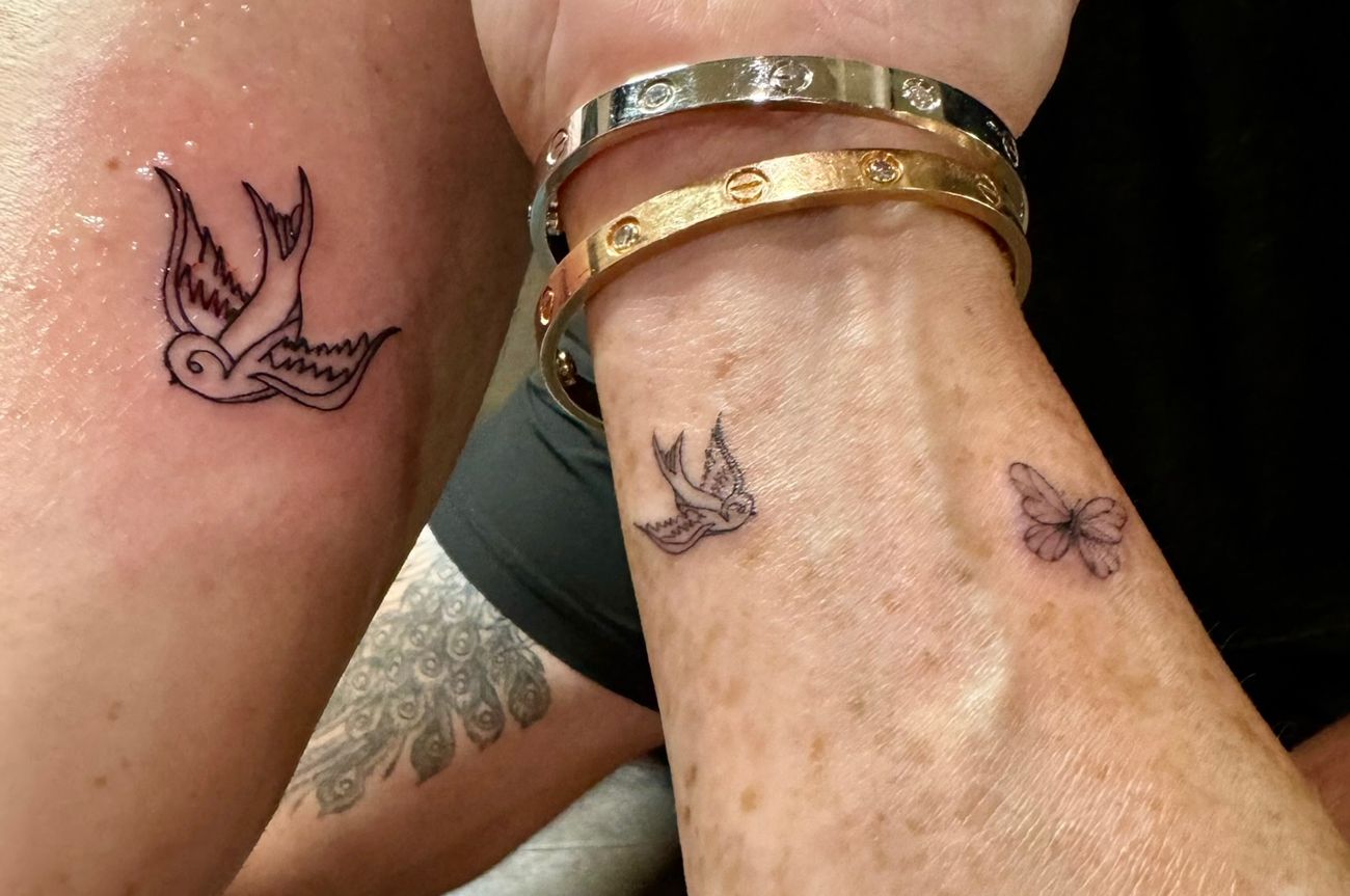 Two forearms side by side, each with a small swallow tattoo