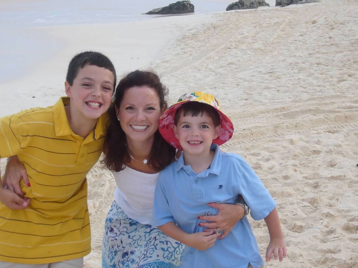 Diane on the beach, hugging her two young sons